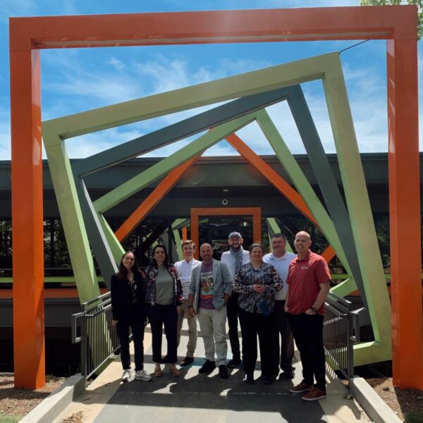 A group of people posing outside at the entrance to the Innovation Center.