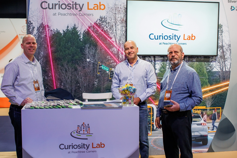 Curiosity Lab Executive Director Brandon Branham and Economic Development Advisors Michael Piha and Guy Tessler man the Curiosity Lab booth at EcoMotion Week 2023