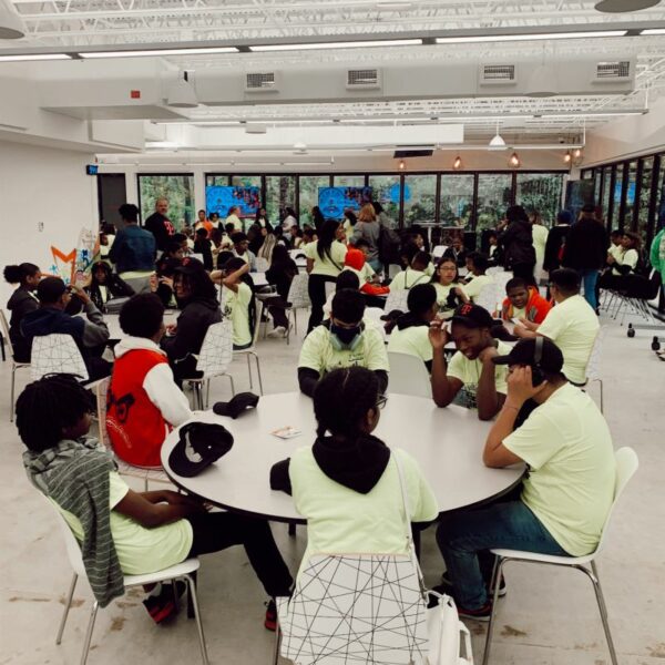 Groups of students sitting at tables in the event space at the Innovation Center