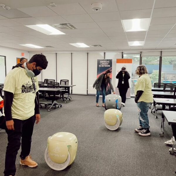 people with 3 robots in the Innovation Center classroom
