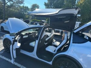 White electric vehicle with doors open.